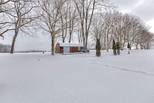 yard covered in snow featuring an outbuilding