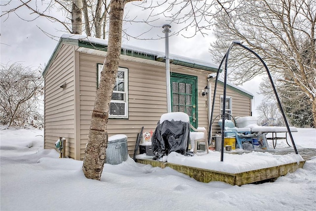 view of snow covered back of property