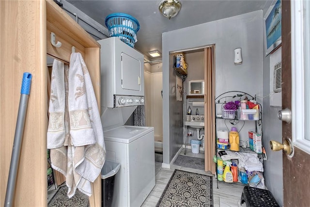 clothes washing area featuring stacked washer / drying machine