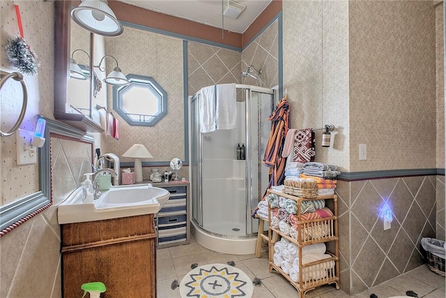 bathroom featuring tile patterned flooring, vanity, an enclosed shower, and tile walls