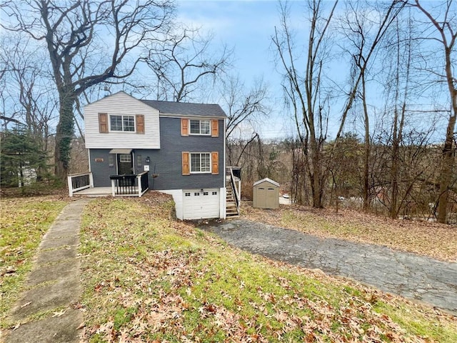 view of front of property featuring covered porch, a garage, and a storage shed