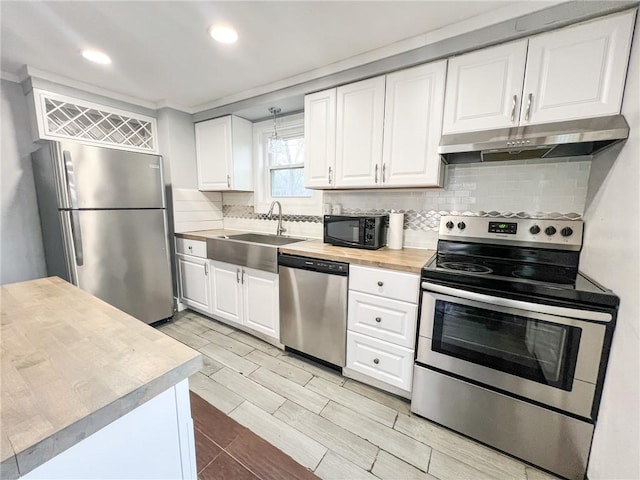 kitchen with stainless steel appliances, white cabinetry, tasteful backsplash, and sink