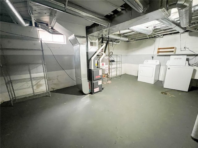 basement with heating unit and washer and clothes dryer