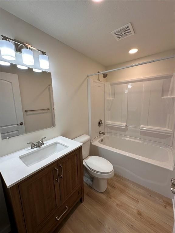 full bathroom with vanity, hardwood / wood-style flooring, toilet, and tub / shower combination