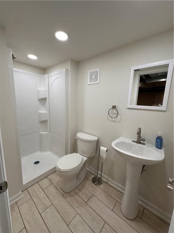 bathroom featuring toilet and walk in shower