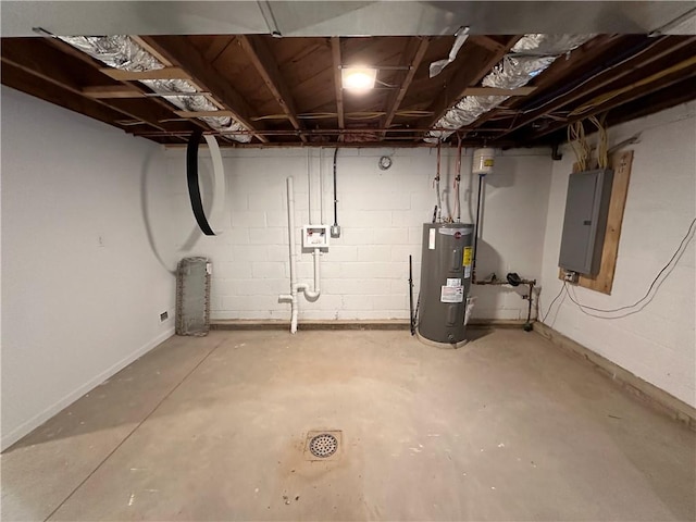 basement featuring electric panel and water heater