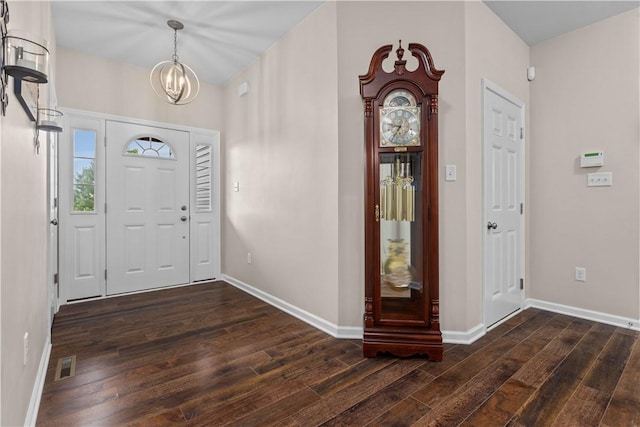 entrance foyer with dark hardwood / wood-style floors and an inviting chandelier