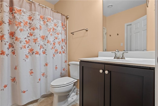 bathroom with toilet, vanity, and tile patterned floors