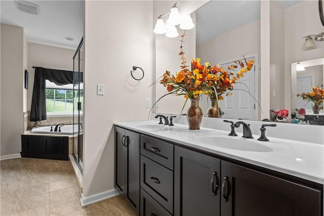 bathroom with tile patterned flooring, vanity, a chandelier, and a tub