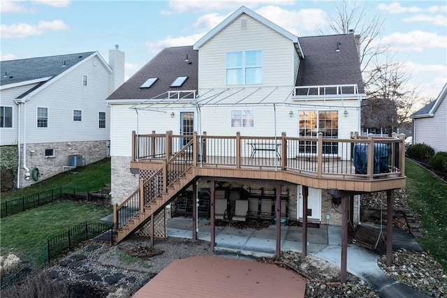 rear view of property featuring a yard, cooling unit, a patio, and a deck