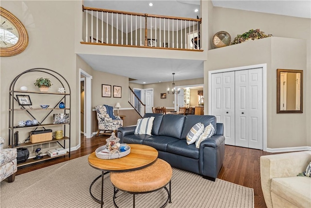 living room featuring a chandelier, hardwood / wood-style floors, and a towering ceiling