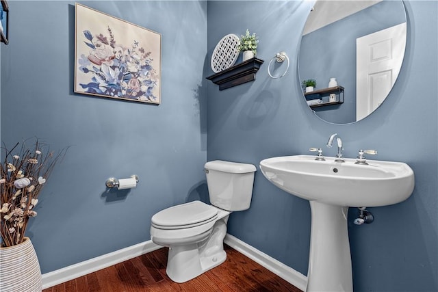 bathroom with hardwood / wood-style flooring and toilet