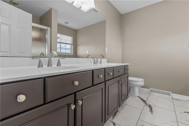 bathroom with vanity, toilet, and a shower with shower door