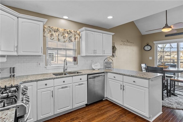 kitchen featuring pendant lighting, sink, white cabinetry, kitchen peninsula, and stainless steel appliances