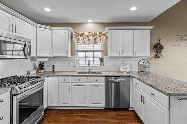 kitchen featuring light stone counters, sink, white cabinets, and stainless steel appliances