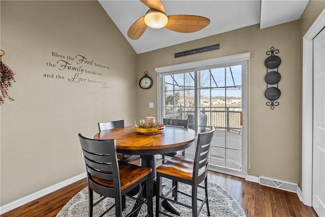 dining area featuring dark hardwood / wood-style floors, ceiling fan, and vaulted ceiling