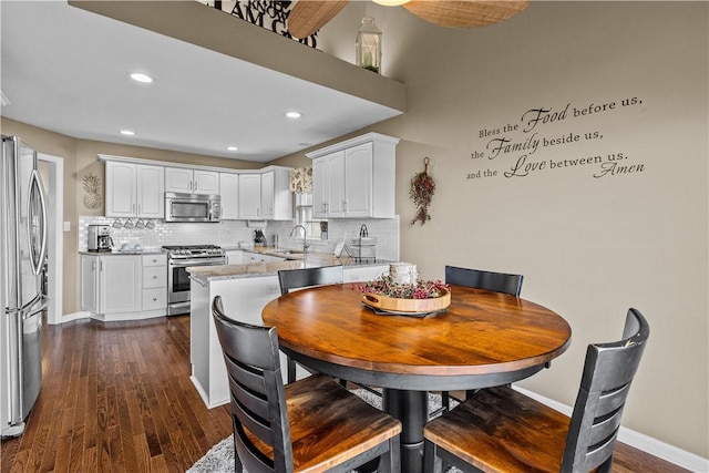 dining area featuring sink and dark wood-type flooring