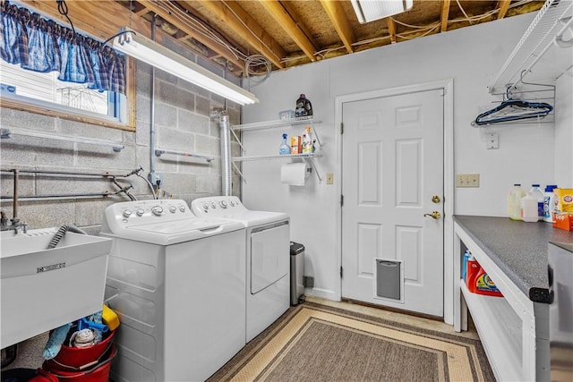 clothes washing area with washing machine and clothes dryer and sink