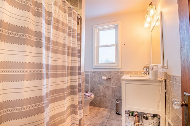 bathroom featuring curtained shower, tile patterned floors, toilet, vanity, and tile walls