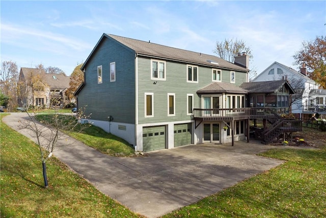 back of house featuring a deck and a garage