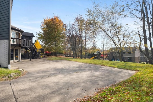 view of yard featuring a playground and a wooden deck