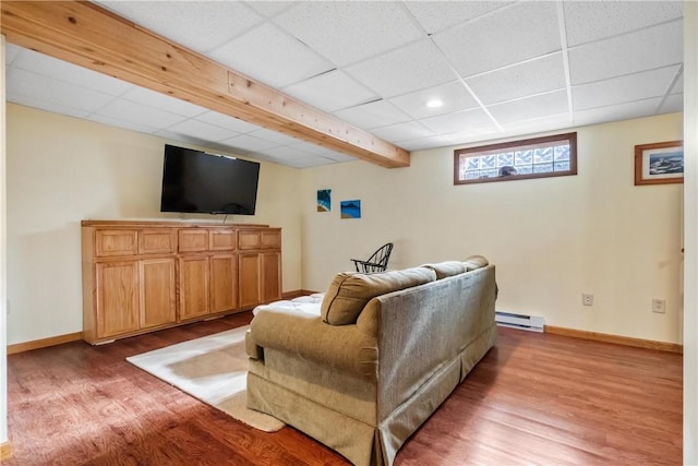 living room featuring hardwood / wood-style floors, a paneled ceiling, and baseboard heating