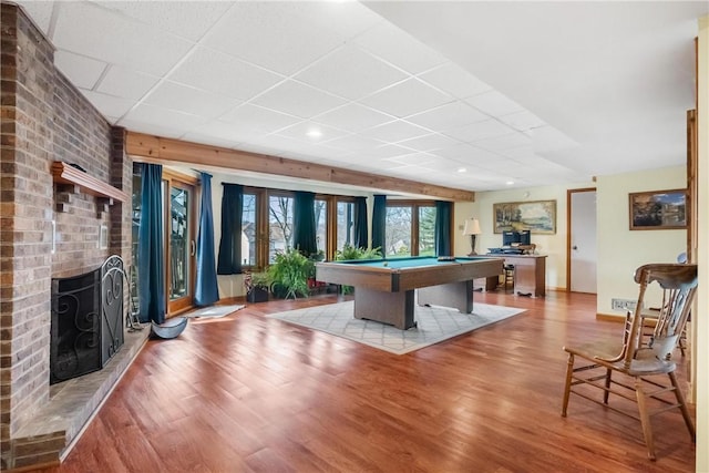 recreation room with hardwood / wood-style flooring, a fireplace, a drop ceiling, and billiards