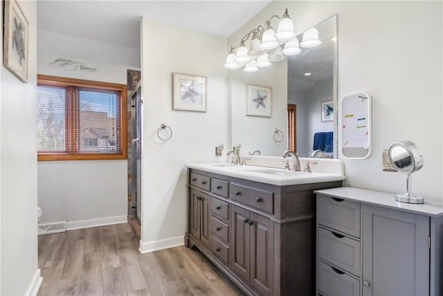 bathroom featuring hardwood / wood-style flooring, vanity, and an enclosed shower