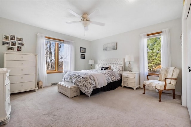 bedroom featuring multiple windows, light carpet, and ceiling fan