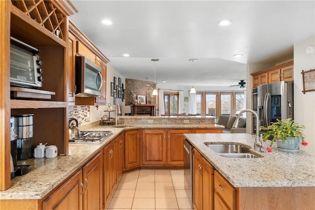 kitchen featuring ceiling fan, pendant lighting, stainless steel appliances, and sink