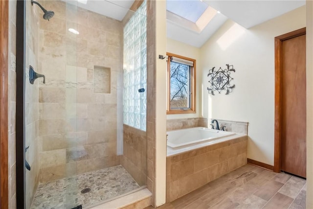 bathroom with independent shower and bath and a skylight