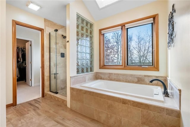 bathroom with plus walk in shower, wood-type flooring, and vaulted ceiling