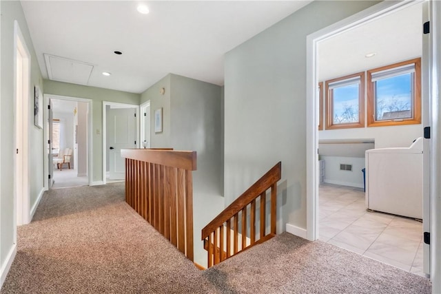 hall with washer / dryer, light colored carpet, and a healthy amount of sunlight