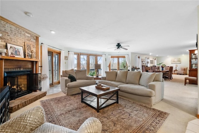 living room with ceiling fan and a fireplace