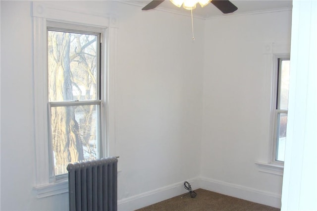 carpeted spare room with radiator, ornamental molding, and ceiling fan