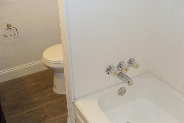 bathroom featuring hardwood / wood-style floors, toilet, and shower / tub combination