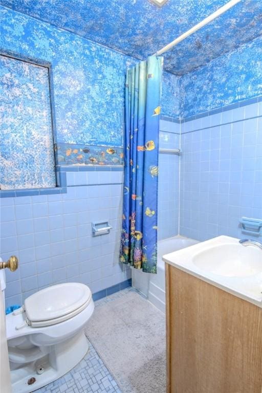 full bathroom featuring sink, tile patterned flooring, toilet, shower / bath combo with shower curtain, and tile walls