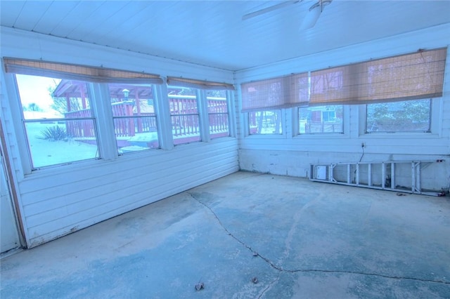 unfurnished sunroom with ceiling fan