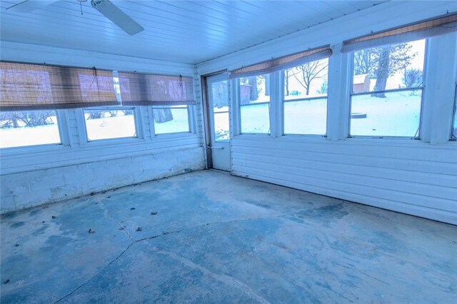 unfurnished sunroom featuring ceiling fan and a wealth of natural light