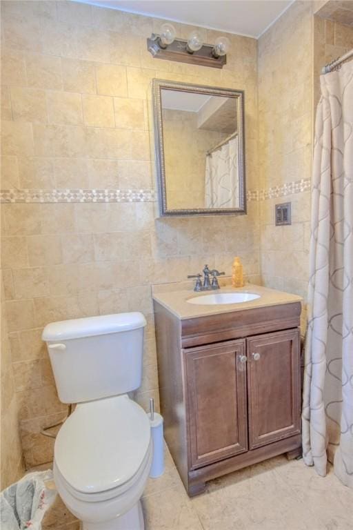 bathroom with vanity, toilet, tile walls, and curtained shower