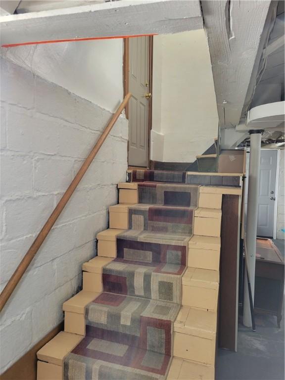 stairs with concrete flooring