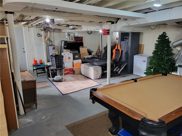 basement with water heater, pool table, and refrigerator