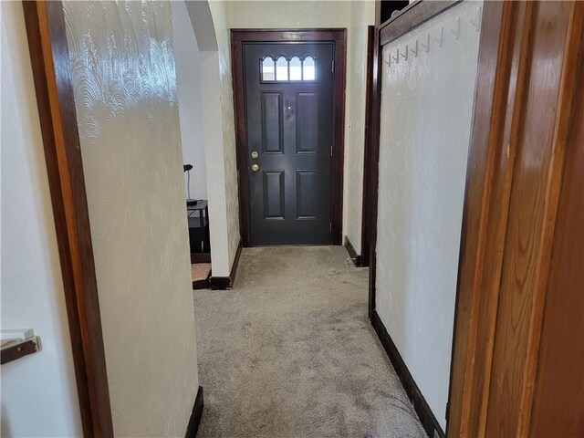 doorway to outside featuring light colored carpet