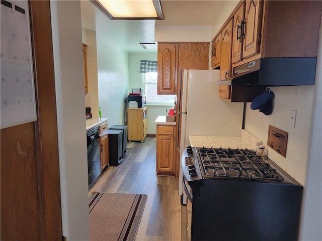 kitchen featuring white refrigerator, dishwasher, gas range oven, and light hardwood / wood-style flooring