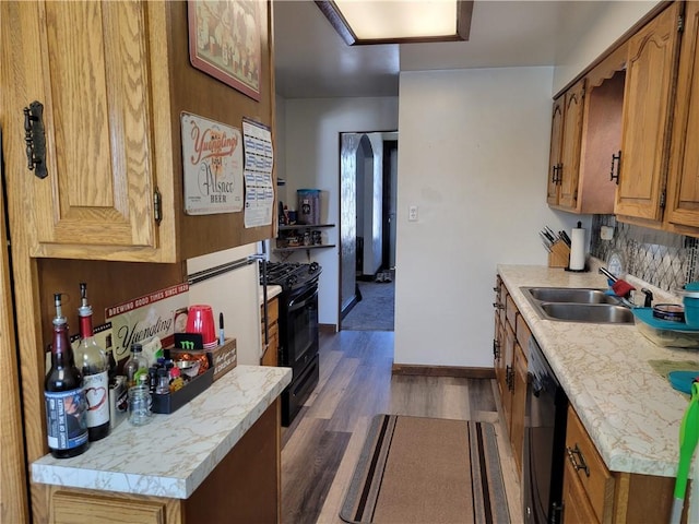 kitchen featuring tasteful backsplash, sink, dark wood-type flooring, and black appliances