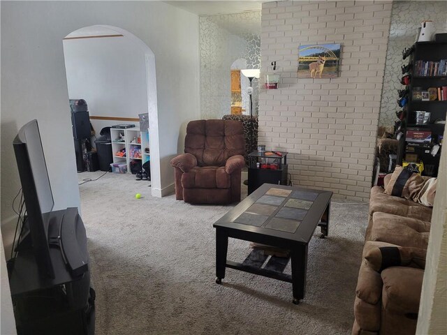 living room featuring carpet floors and brick wall