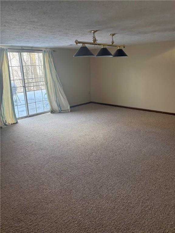 empty room featuring a textured ceiling and carpet floors