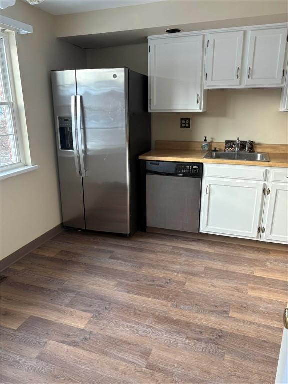 kitchen featuring light hardwood / wood-style floors, white cabinetry, sink, and appliances with stainless steel finishes