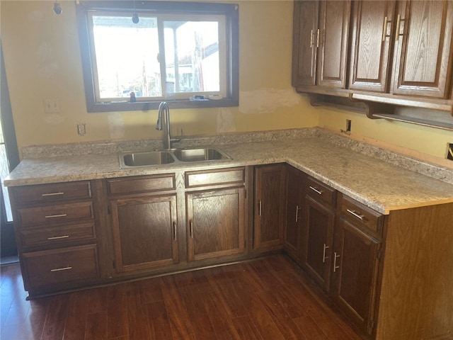 kitchen with light stone counters, dark hardwood / wood-style flooring, and sink