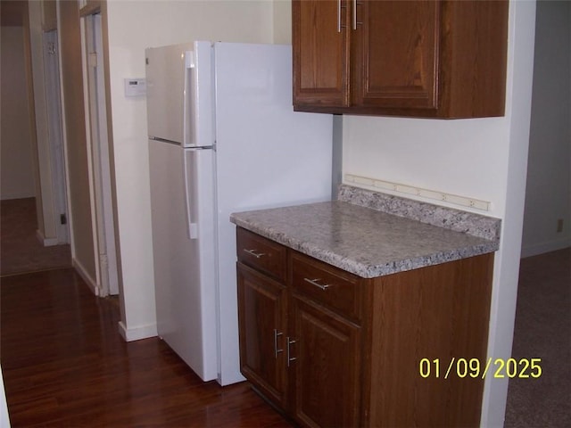 kitchen featuring dark hardwood / wood-style flooring and white refrigerator